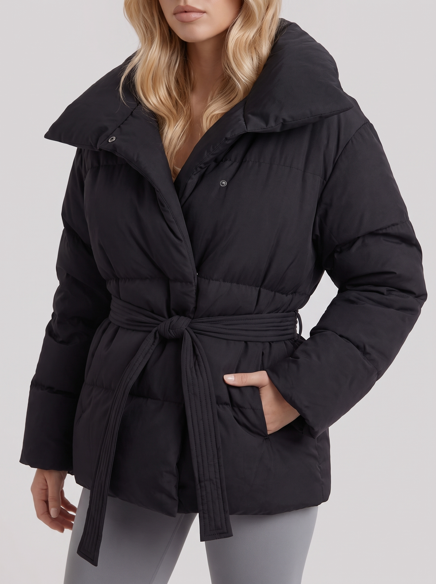 Women's black puffer jacket with quilted panels and zip front