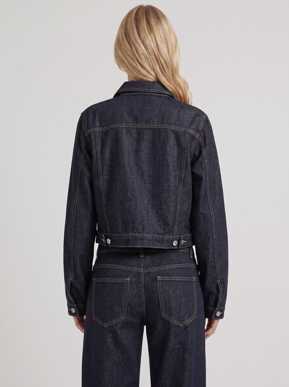 Women indigo cropped denim trucker jacket with contrast topstitching and flap pockets, back view
