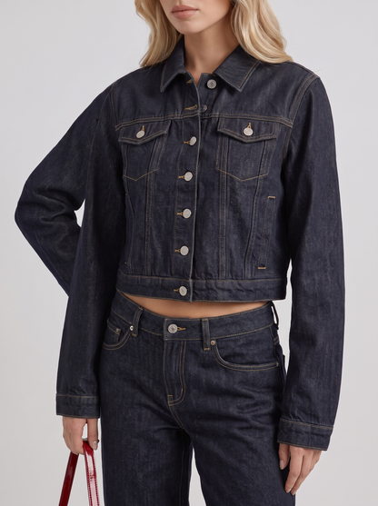 Women indigo cropped denim trucker jacket with contrast topstitching and flap pockets, fabric closeup