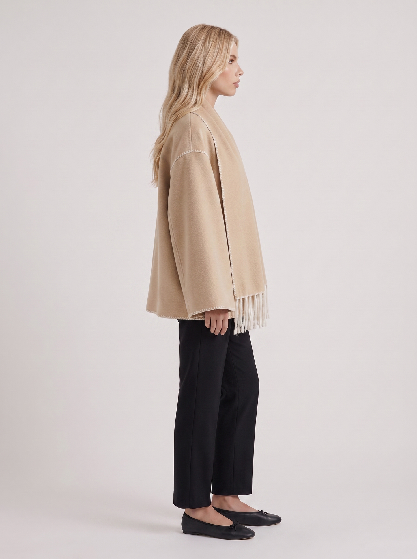 Women beige wool blend coat with attached fringed scarf and blanket stitch edges, side view
