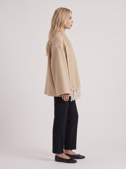 Women beige wool blend coat with attached fringed scarf and blanket stitch edges, side view