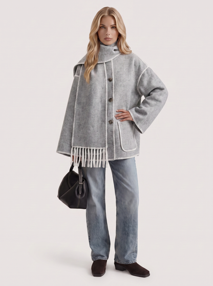 Women light gray wool blend coat with attached fringed scarf and blanket stitch edges, three quarter view