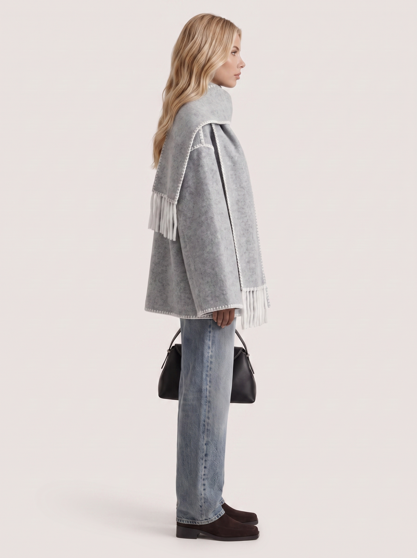Women light gray wool blend coat with attached fringed scarf and blanket stitch edges, side view