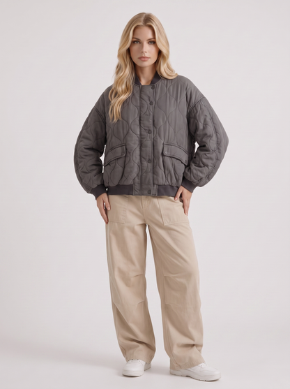 Women charcoal oversized onion quilted bomber jacket with snap front and ribbed trims, three quarter view