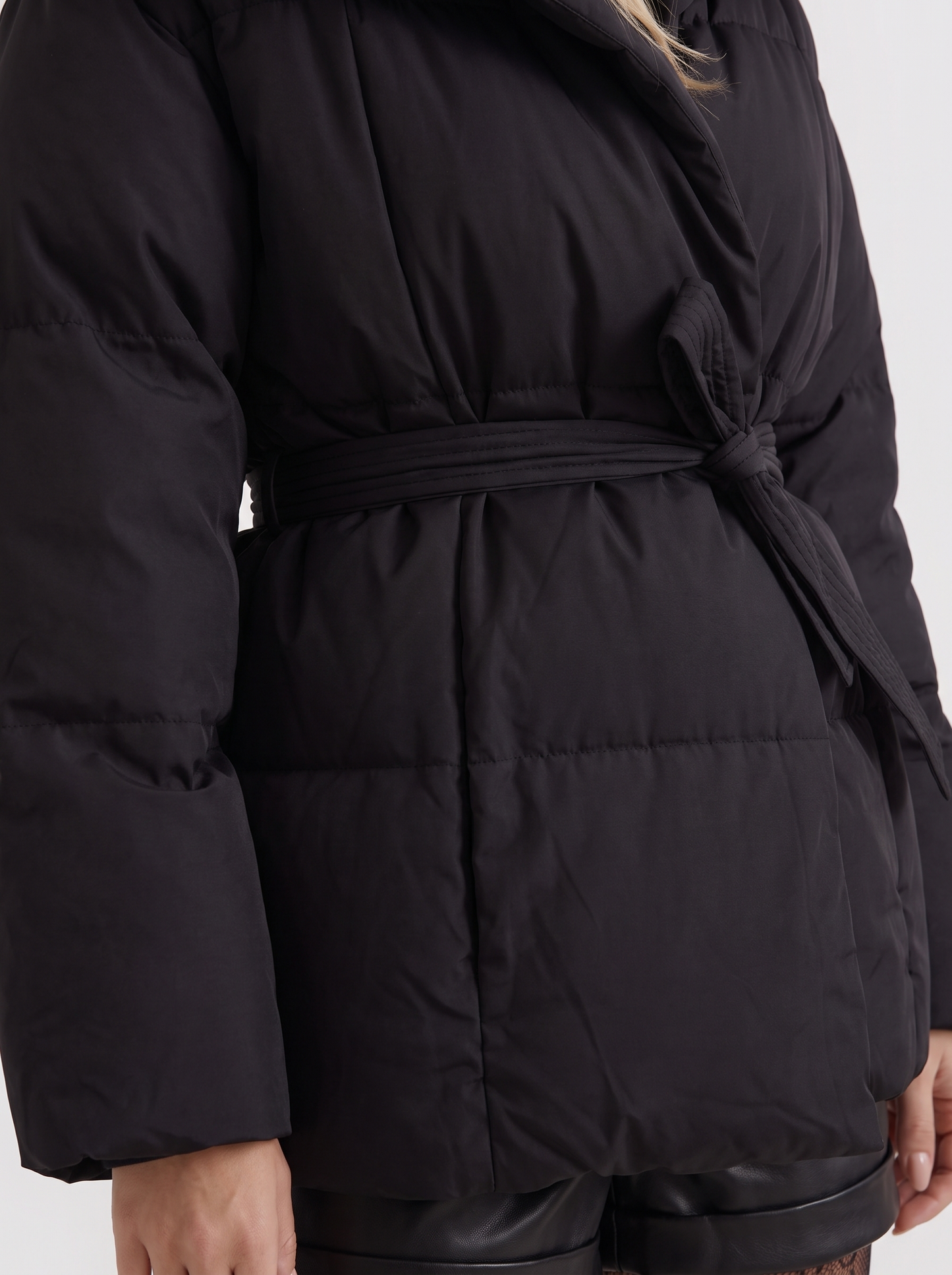 Women black oversized padded jacket with wide portrait collar and tie waist belt, fabric closeup