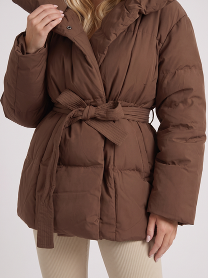 Women brown oversized padded jacket with wide portrait collar and tie waist belt, fabric closeup