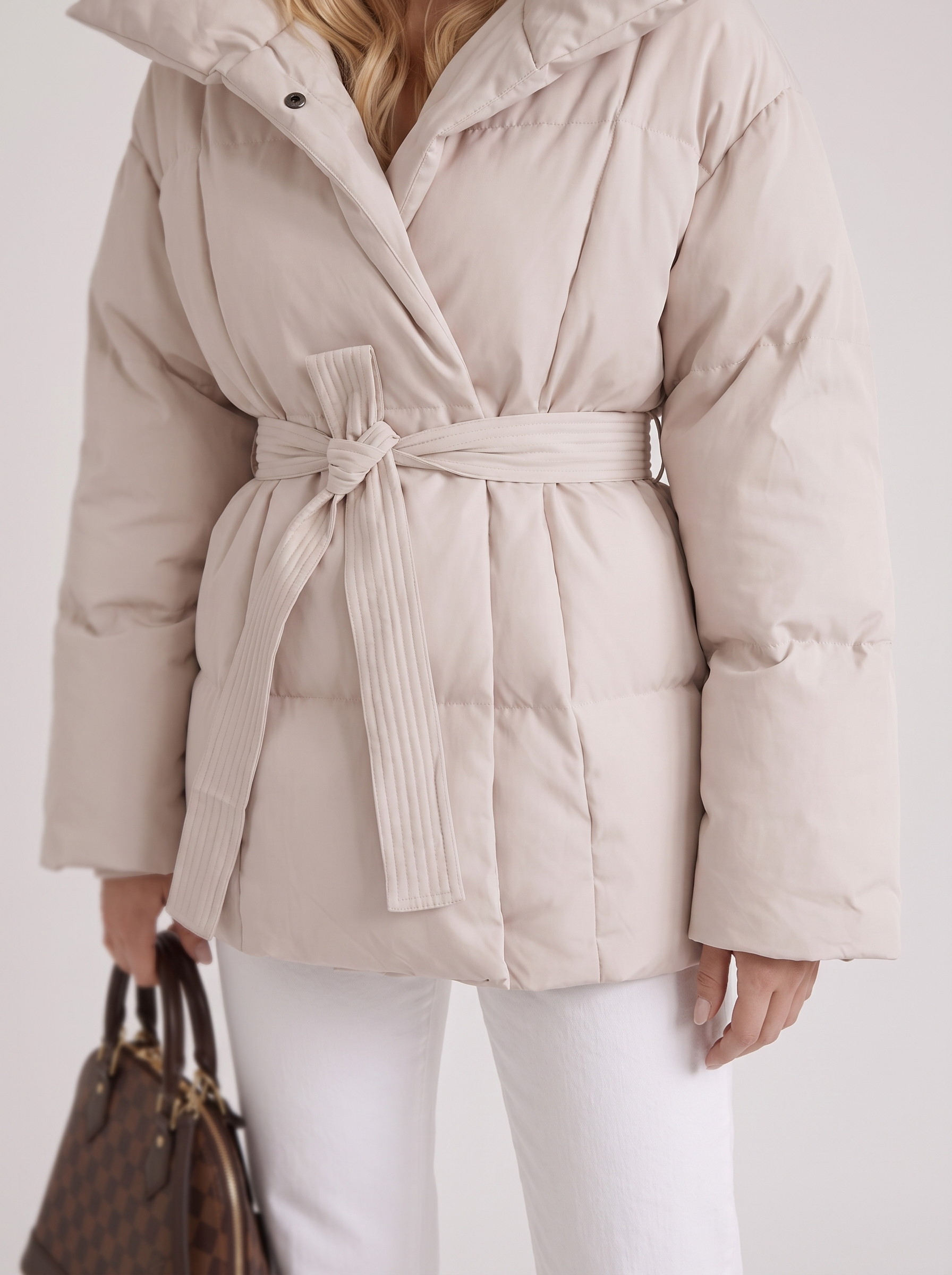 Women cream oversized padded jacket with wide portrait collar and tie waist belt, fabric closeup
