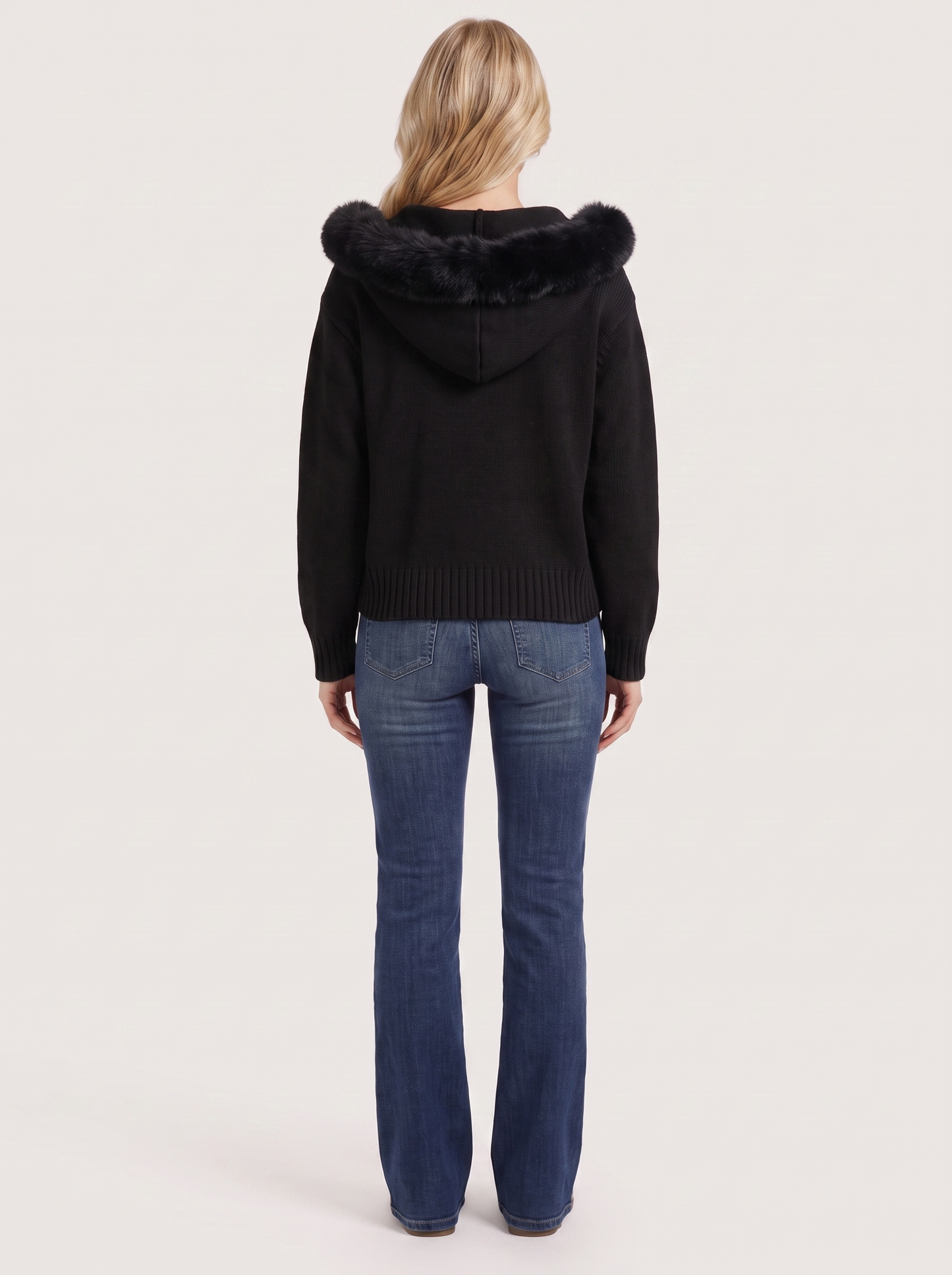 Women black hooded rib knit cardigan with faux fur pompom ties and open front, back view