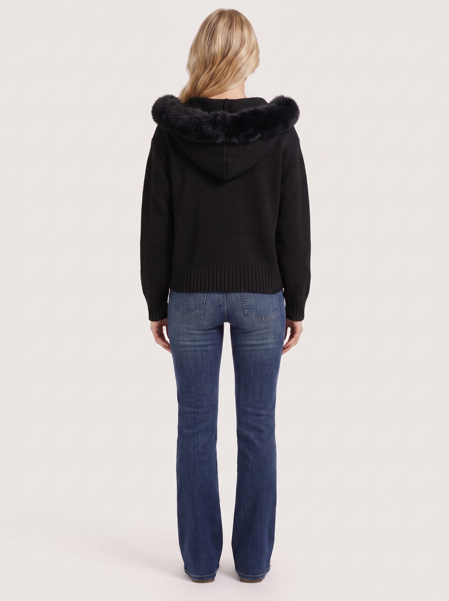 Women black hooded rib knit cardigan with faux fur pompom ties and open front, back view