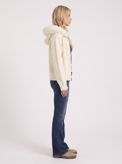 Women white hooded rib knit cardigan with faux fur pompom ties and open front, side view