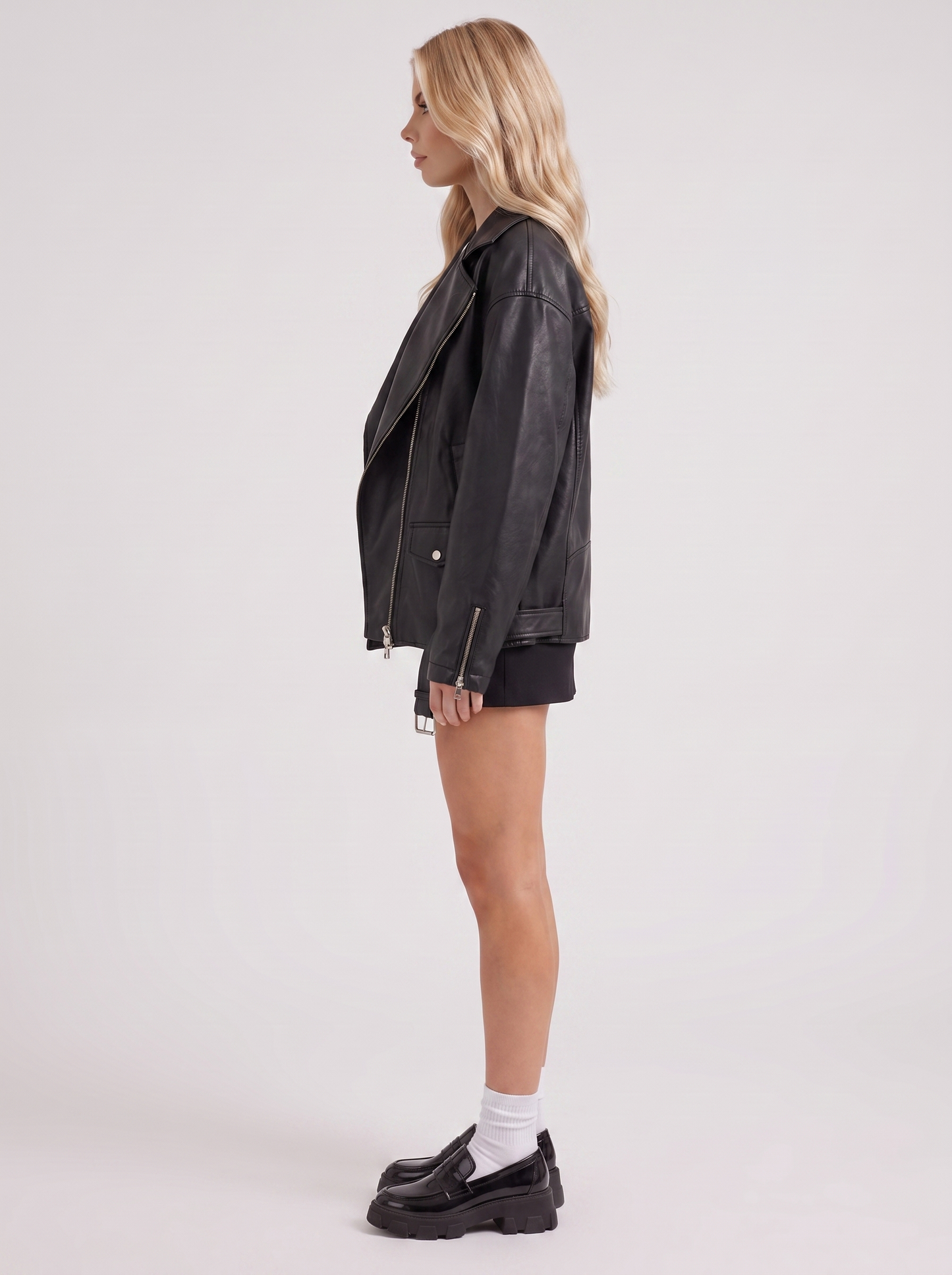 Women black oversized faux leather biker jacket with asymmetric zip and studded belt, side view