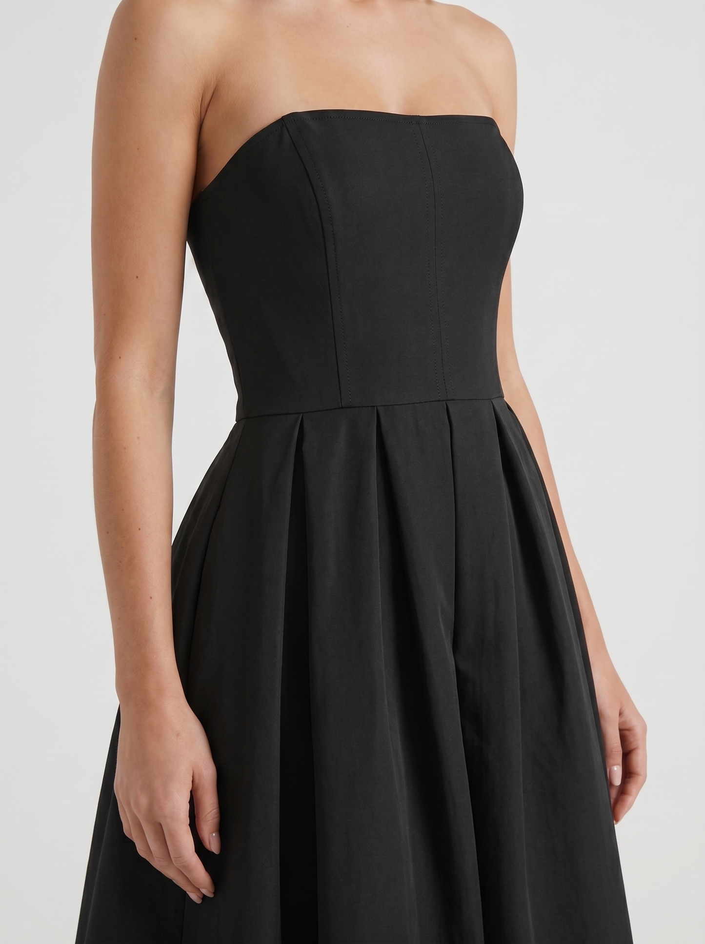 Women black strapless pleated midi dress closeup of bodice and pleat detail