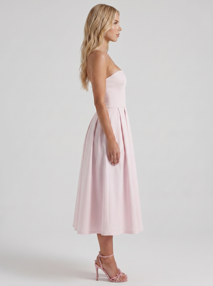 Women blush strapless pleated midi dress with fitted bodice, side profile