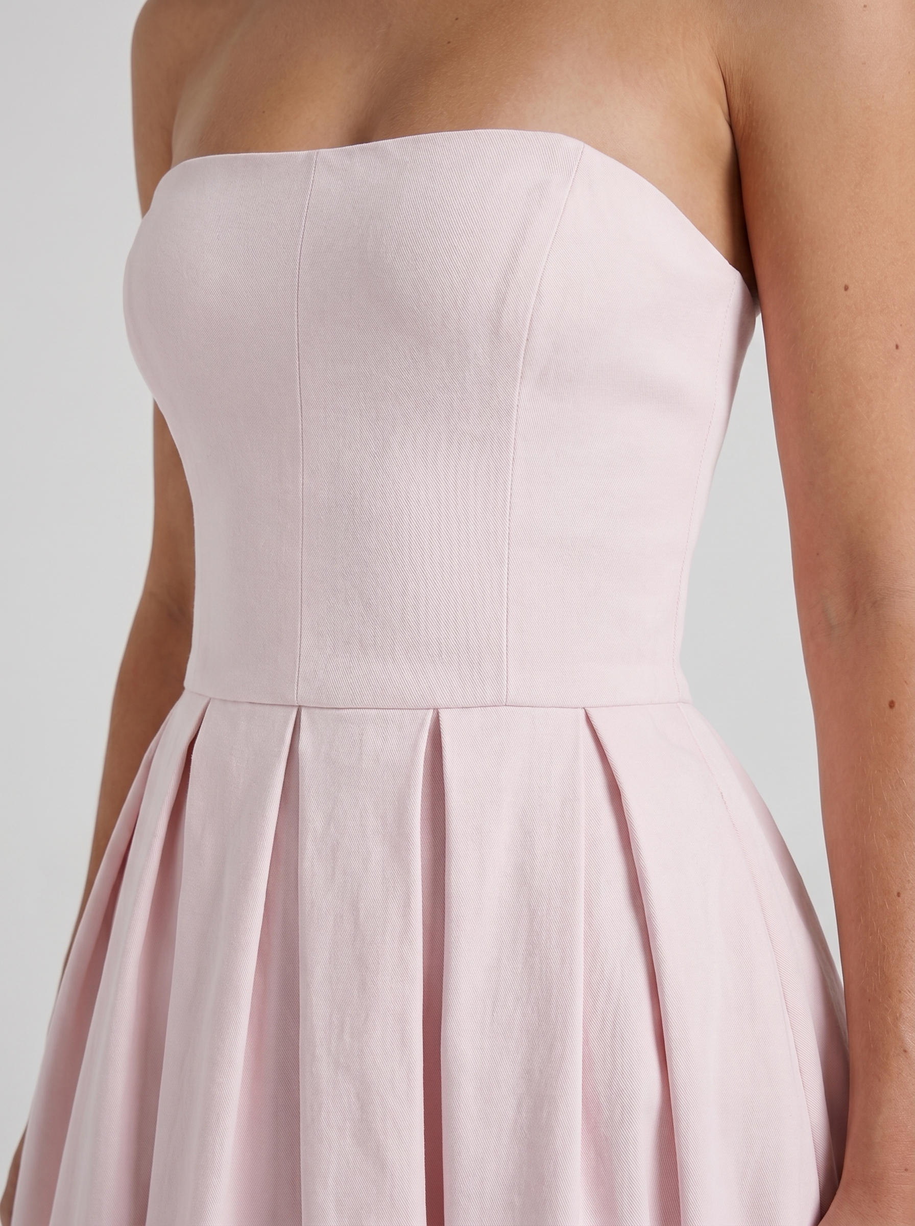 Women blush strapless pleated midi dress closeup of bodice and pleat detail