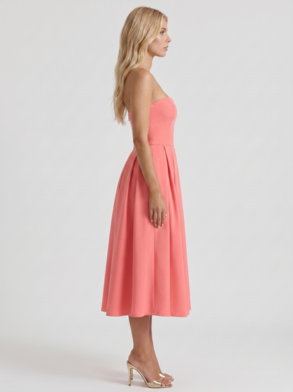 Women coral pink strapless pleated midi dress with fitted bodice, side profile