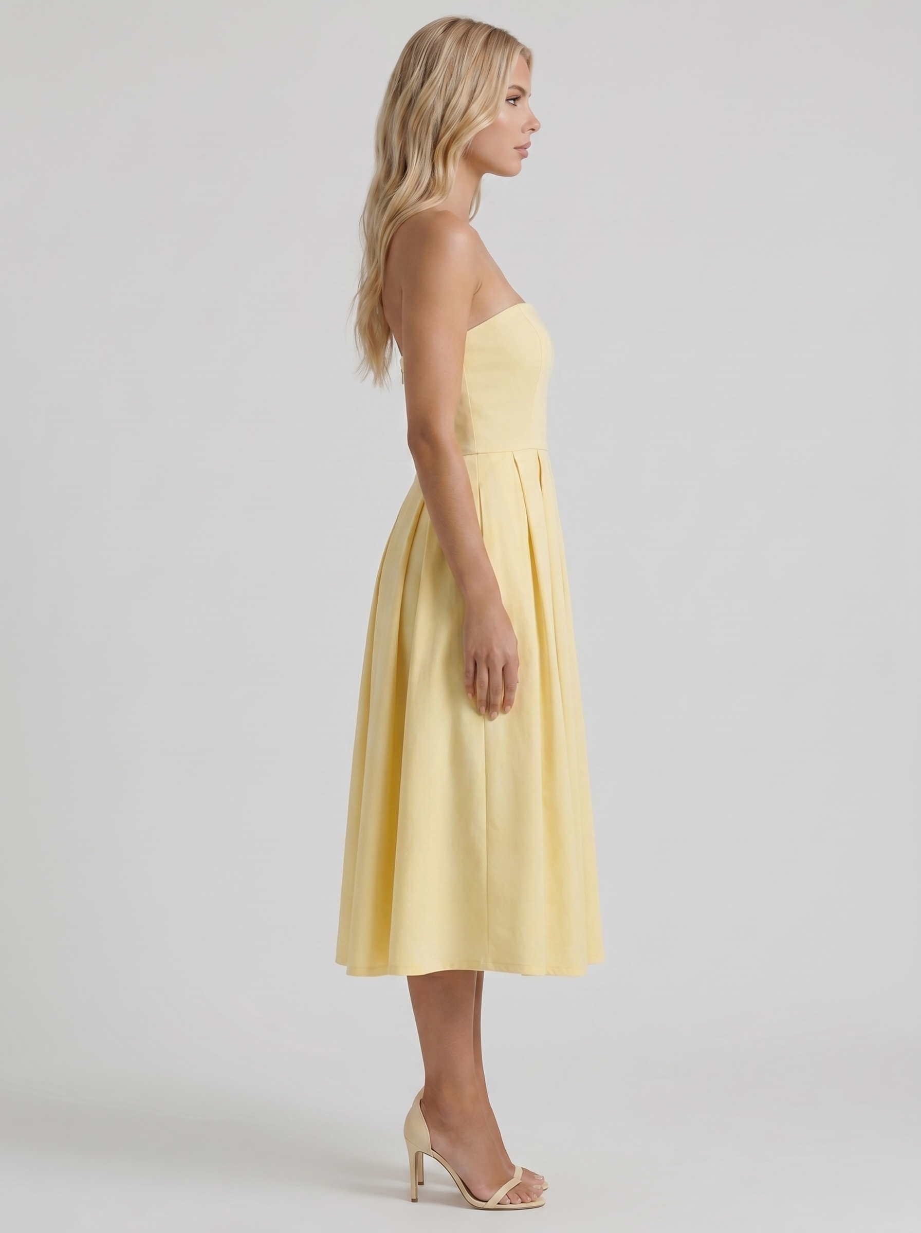 Women lemon strapless pleated midi dress with fitted bodice, side profile