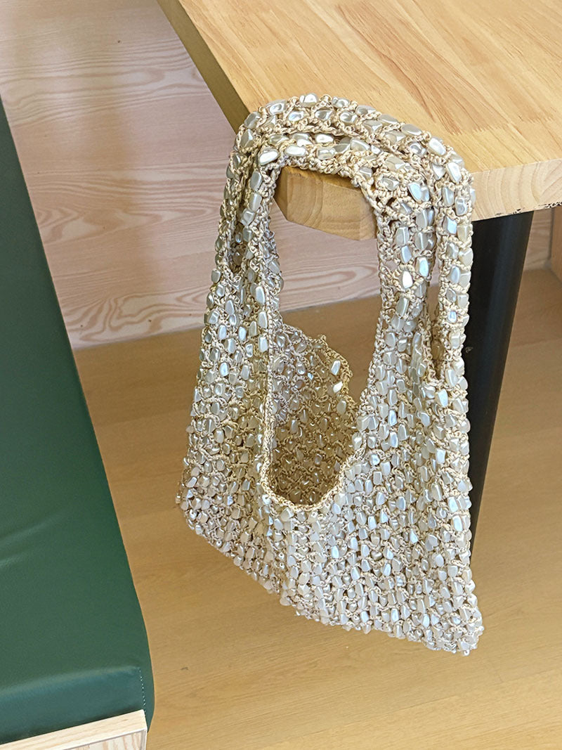 Women ivory shoulder bag with shell detail and woven body