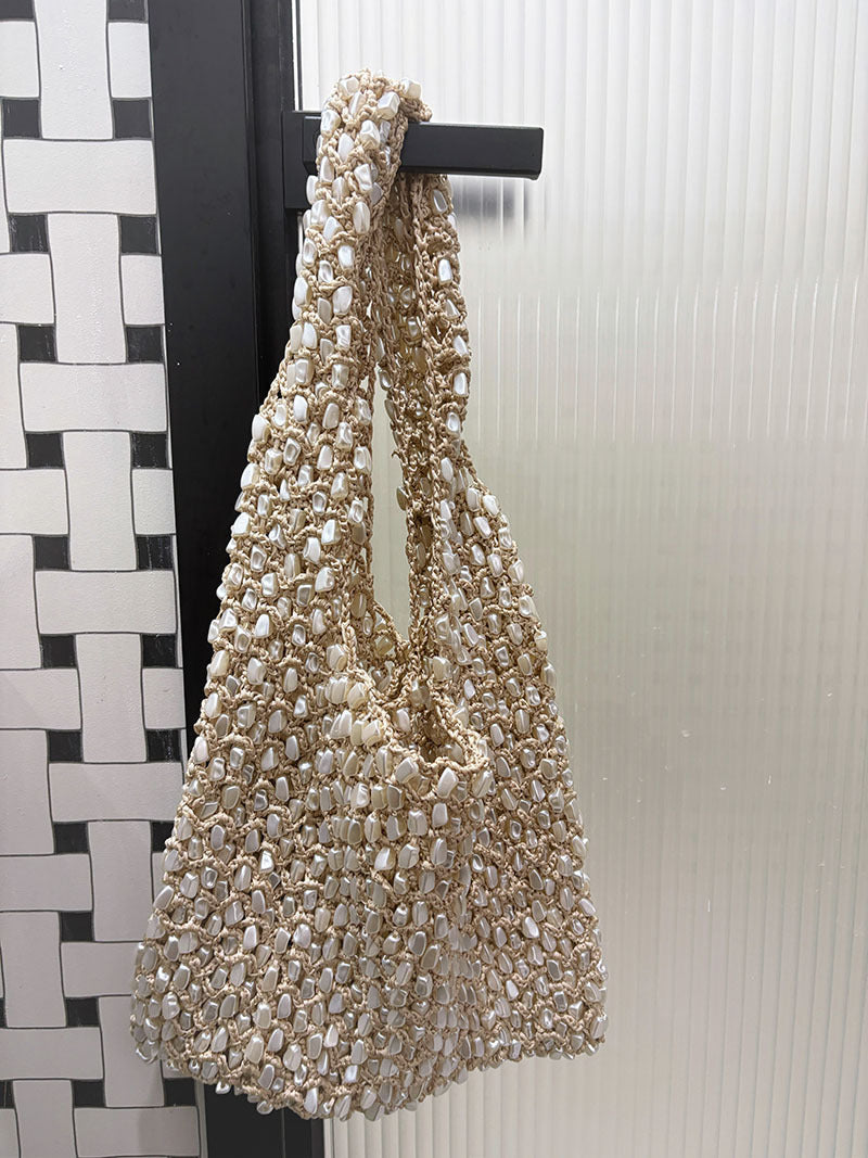 Women ivory shoulder bag with shell detail and woven body