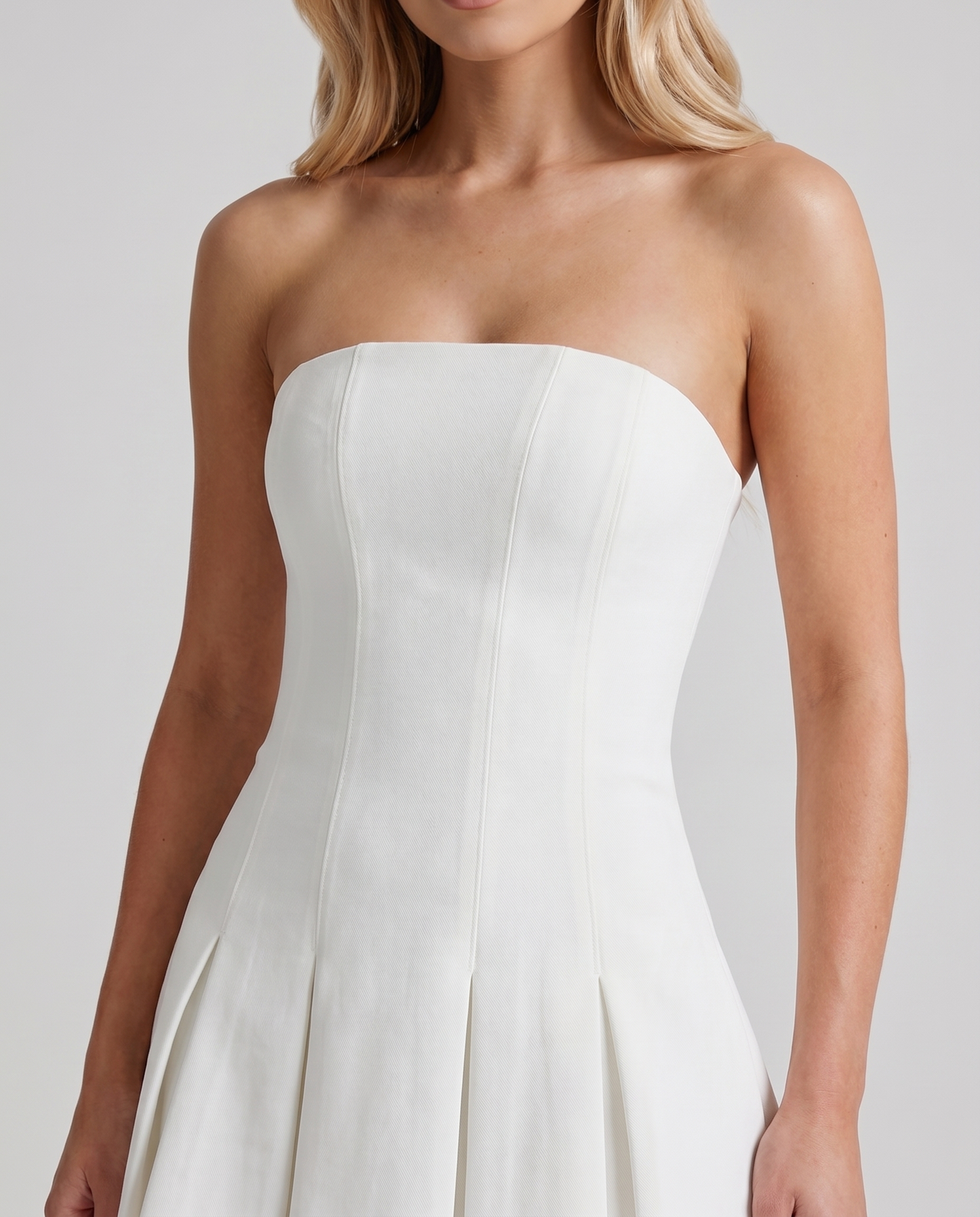Women ivory strapless mini dress closeup of straight neckline, fitted bodice, and paneled seams