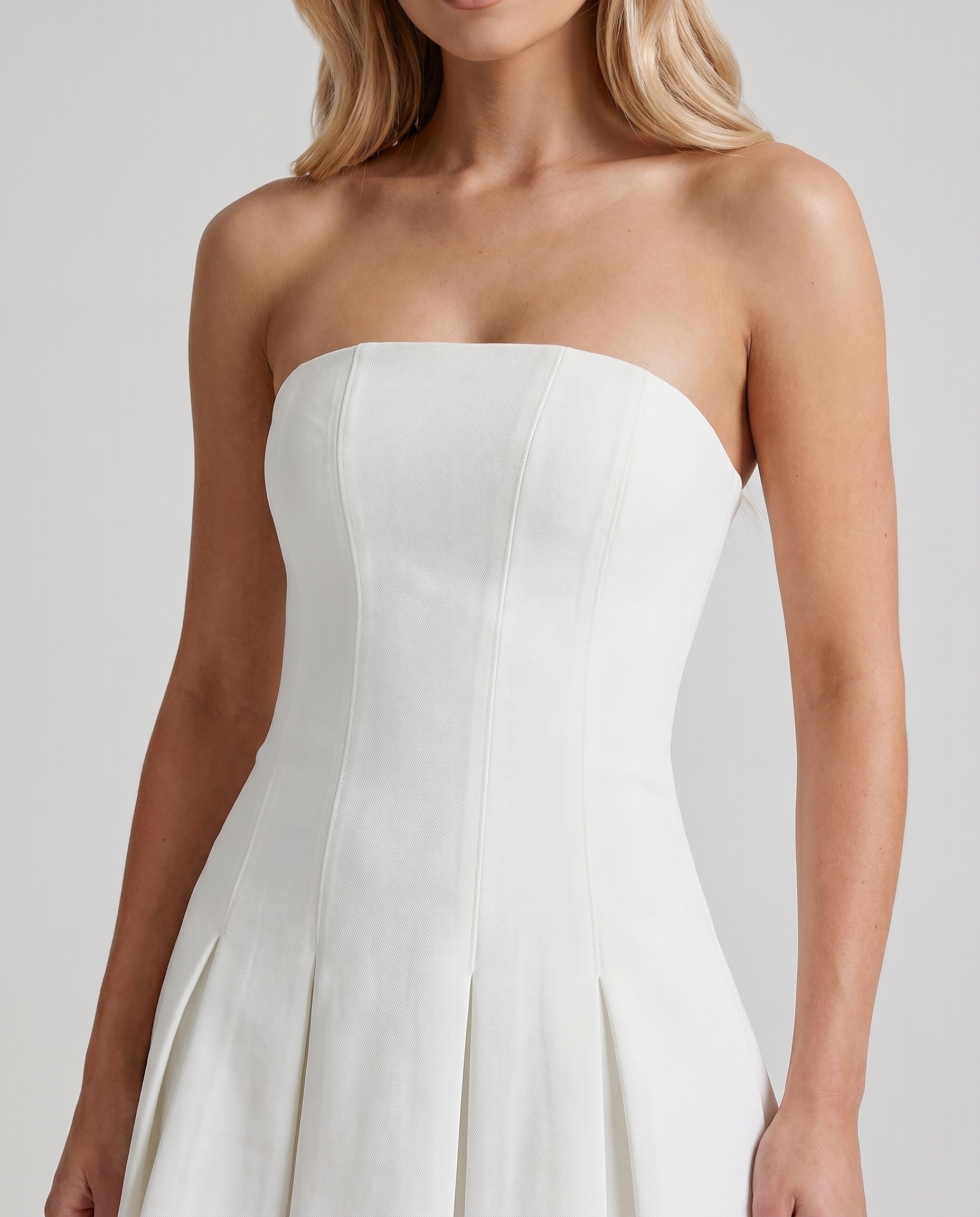 Women ivory strapless mini dress closeup of straight neckline, fitted bodice, and paneled seams