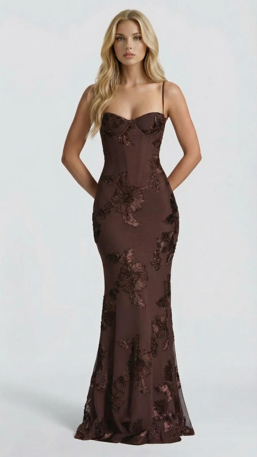 Front view of brown floral maxi dress, hands behind back, showcasing the full-length silhouette and pattern.