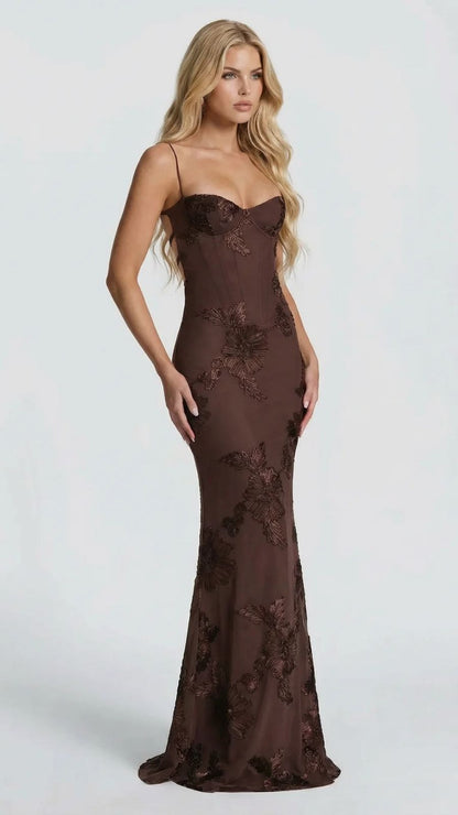 Side view of brown floral maxi dress with intricate embroidery, showcasing the fitted waist and flowing skirt.