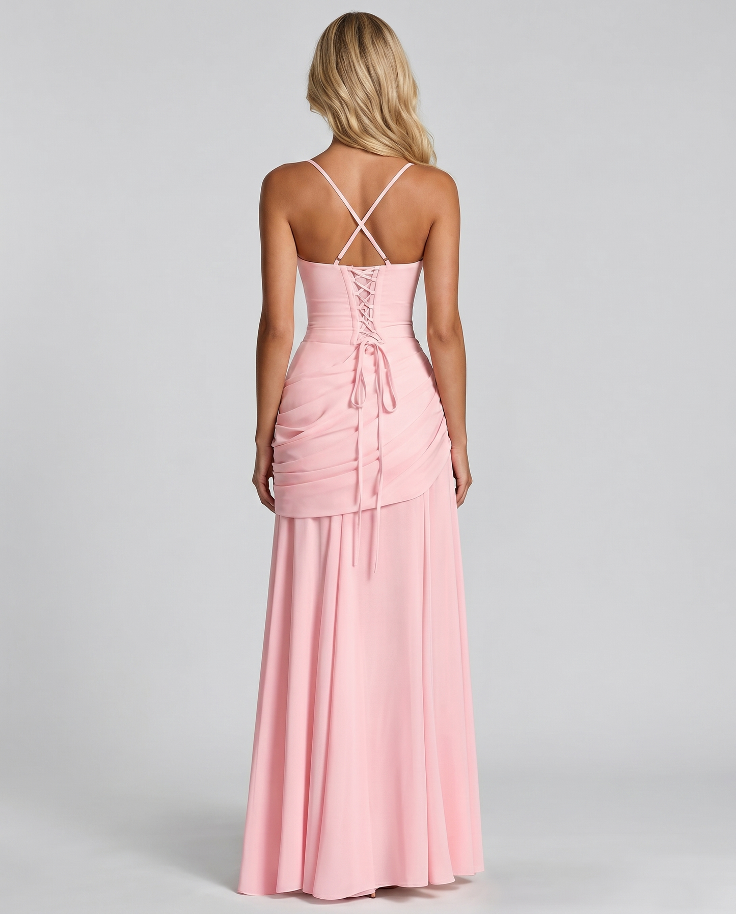 Back view of pink ruched maxi dress with crisscross straps, lace-up back and flowing hem