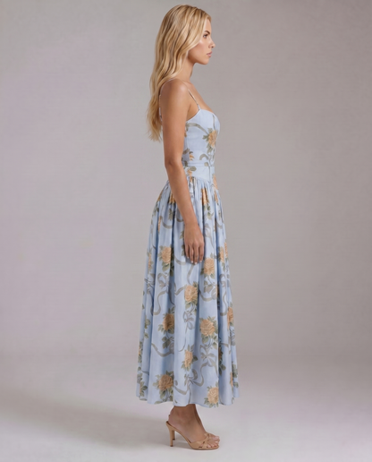 Side profile vintage blue floral midi dress with spaghetti straps, defined waist seam, and full skirt