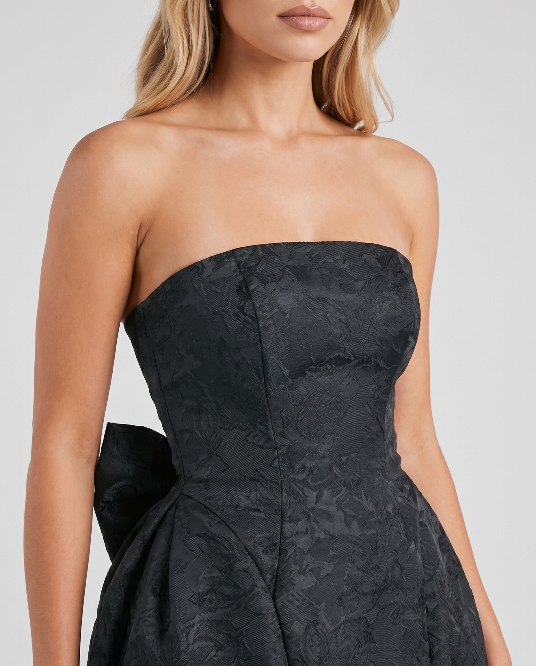 Women black strapless mini dress closeup of fitted bodice and straight strapless neckline