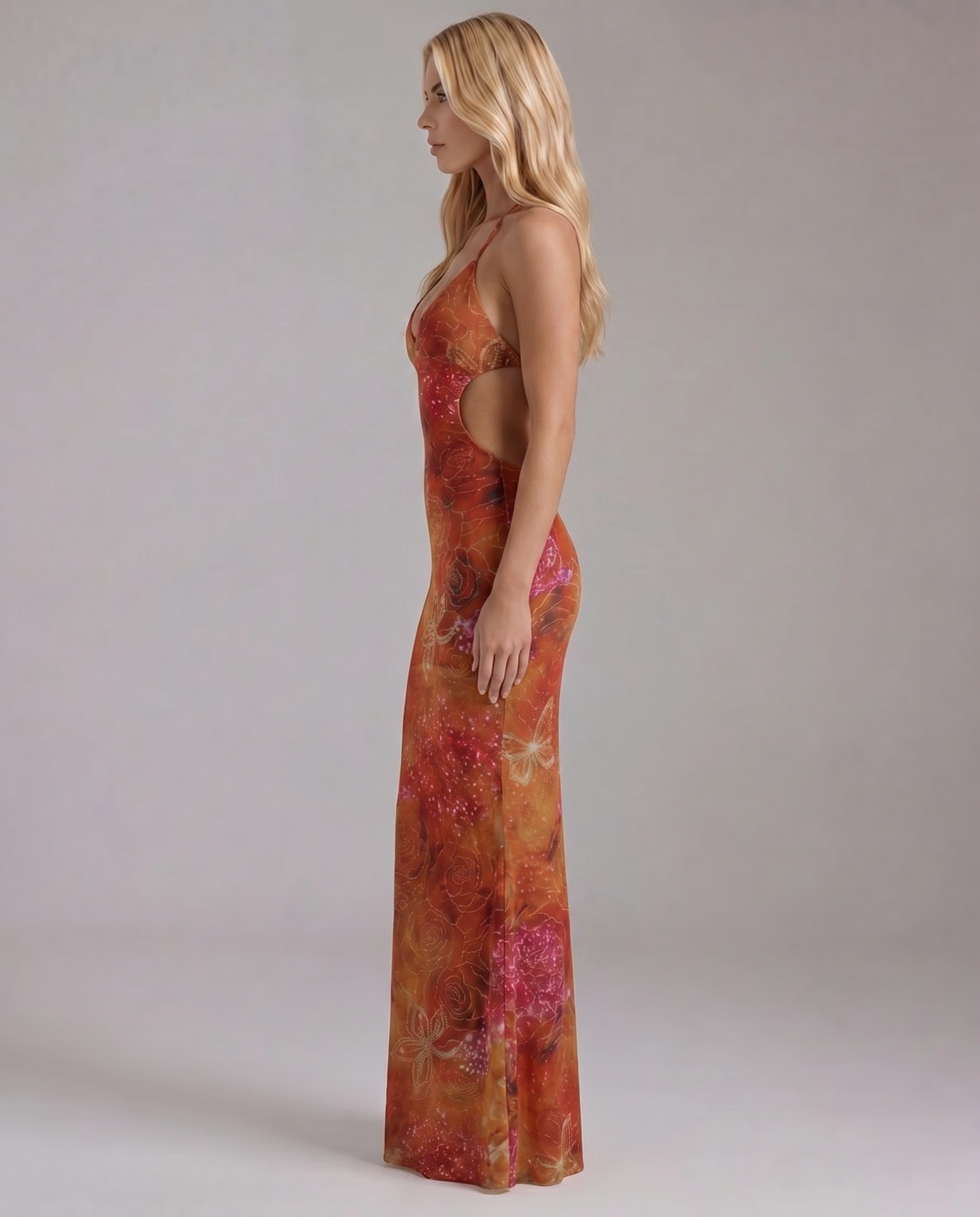 Side profile of the orange print maxi dress, showing the full length and waist cutout details