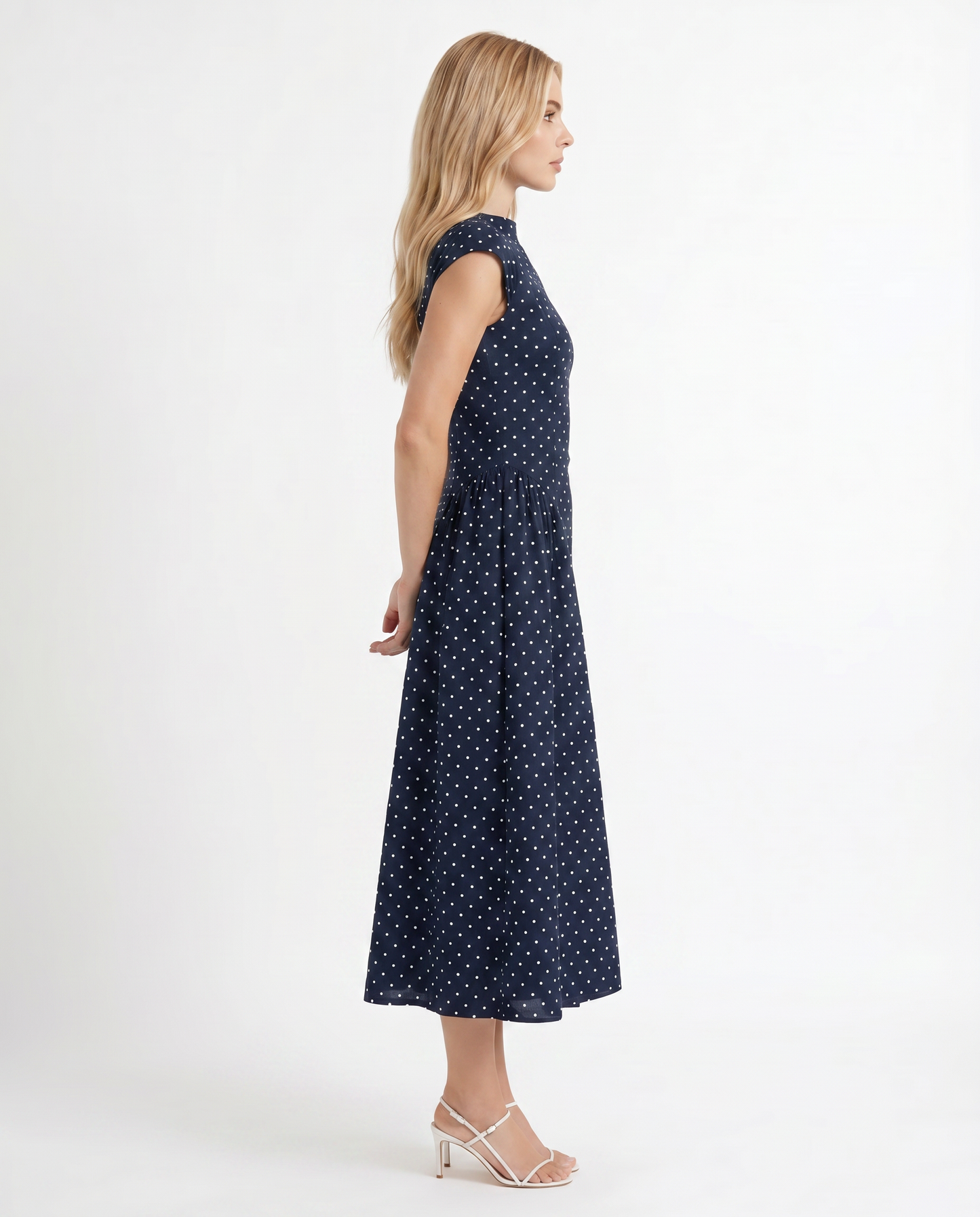 Women navy polka dot midi dress with cap sleeves and fit and flare midi, side profile