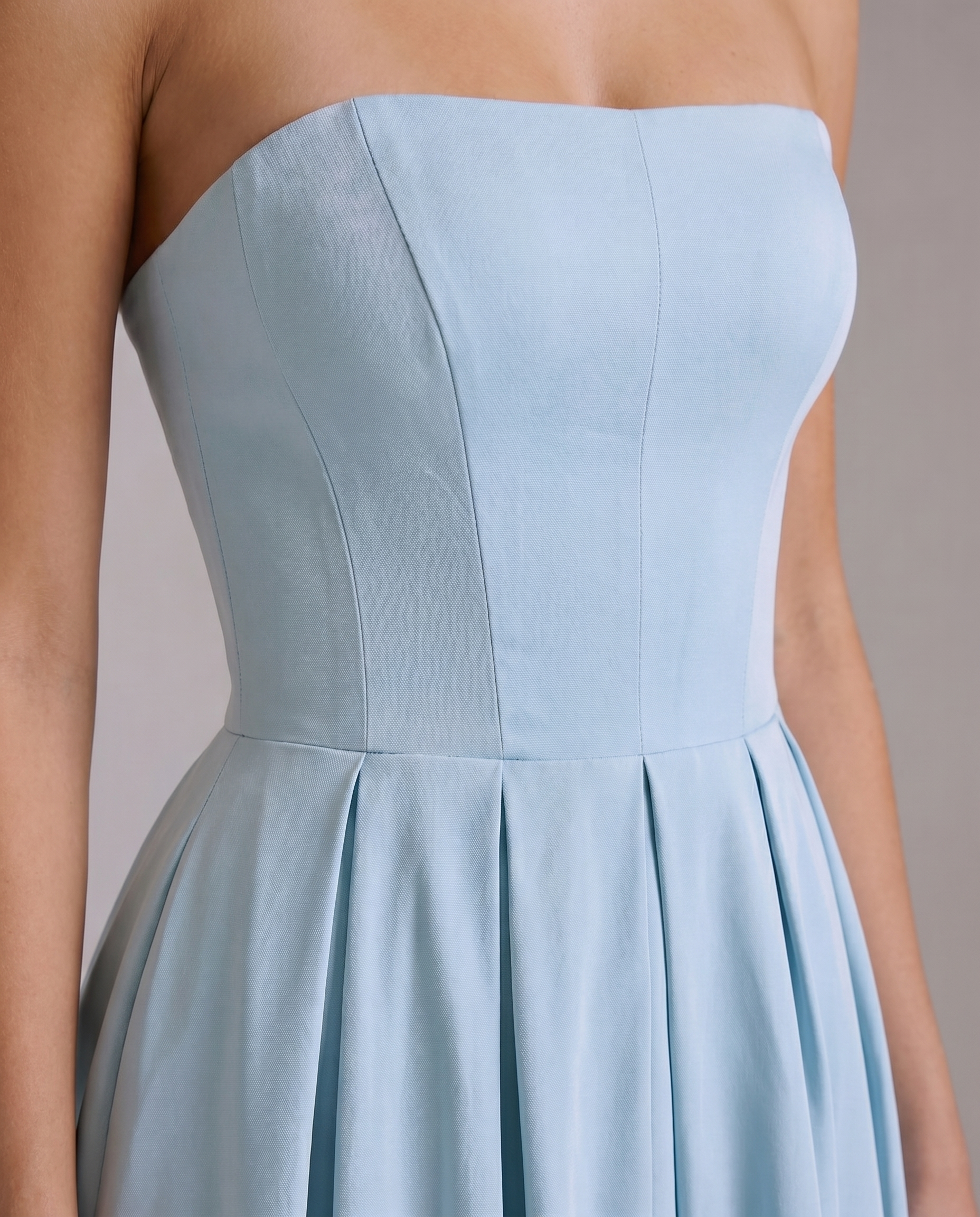 Close-up detail of the light blue strapless midi dress bodice with visible seams and pleated waistline