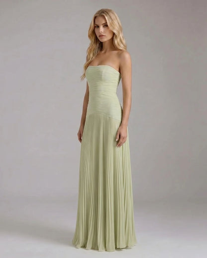 Angled view of the Kenzie Forest maxi dress, showcasing the light green fabric and the elegant pleats of the skirt.