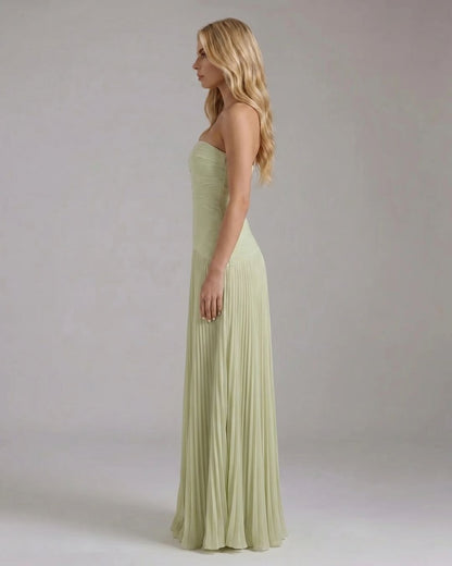 Side profile of the light green Kenzie Forest maxi dress, highlighting the fitted strapless bodice and vertical pleats.