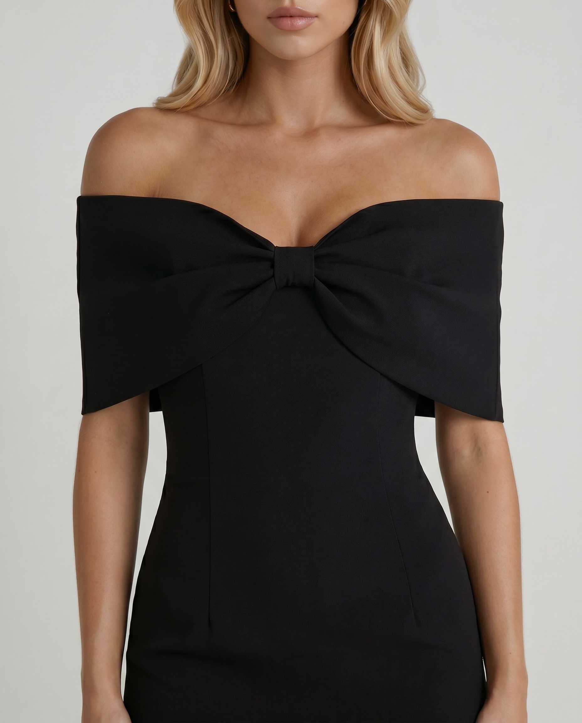 Women black mini dress closeup of off shoulder neckline, center bust bow, and cap sleeves