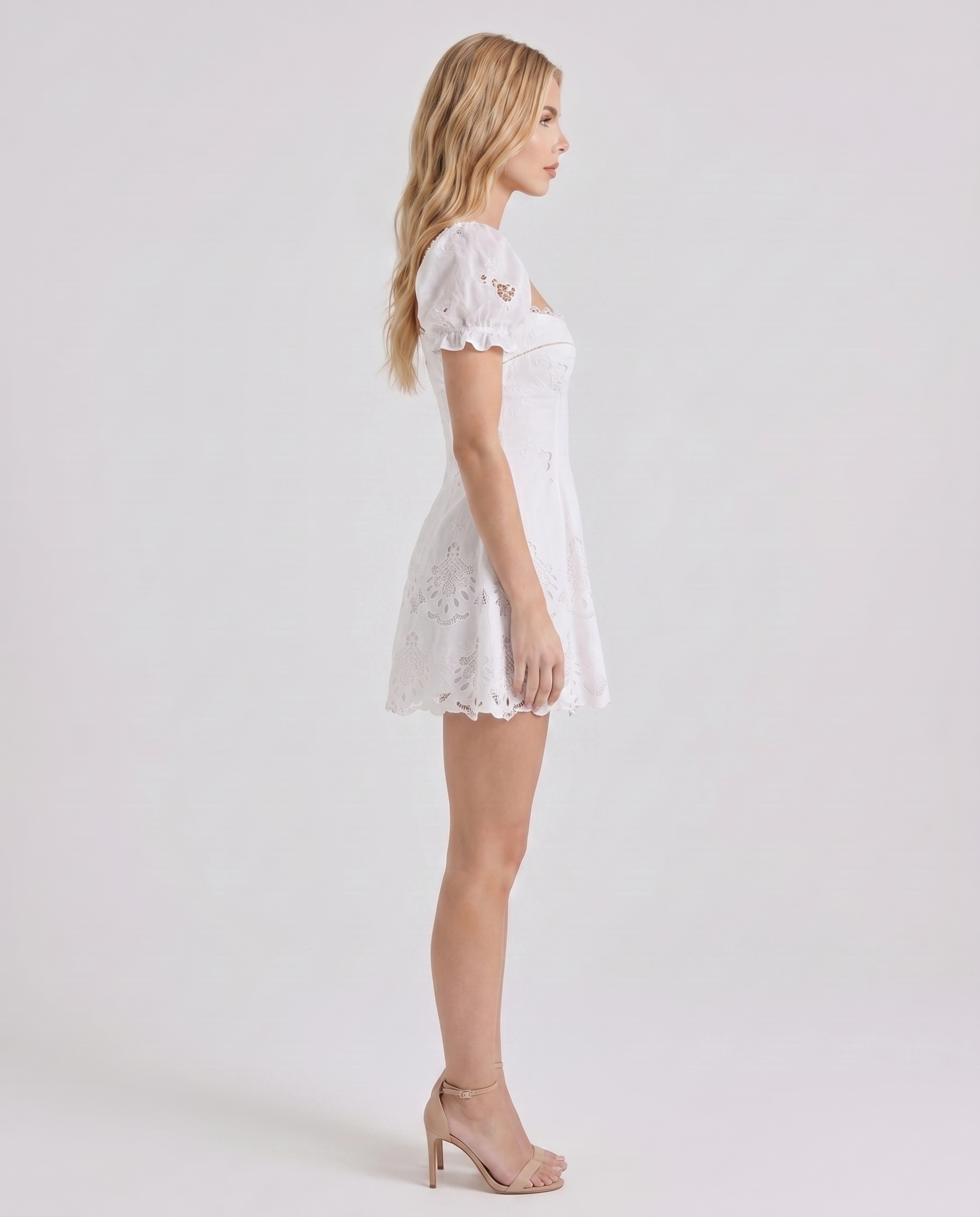 Women white sweetheart mini dress with puff sleeves and scalloped hem, side profile