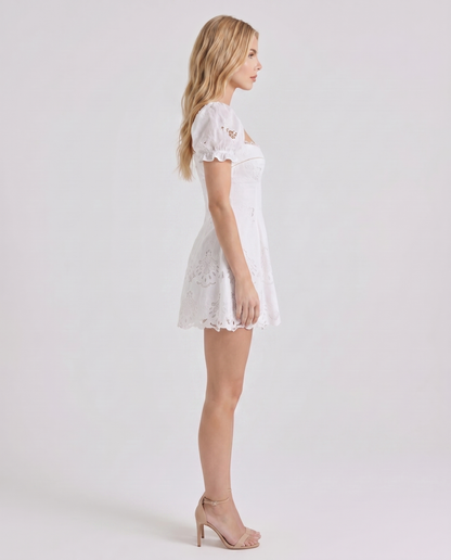 Women white sweetheart mini dress with puff sleeves and scalloped hem, side profile