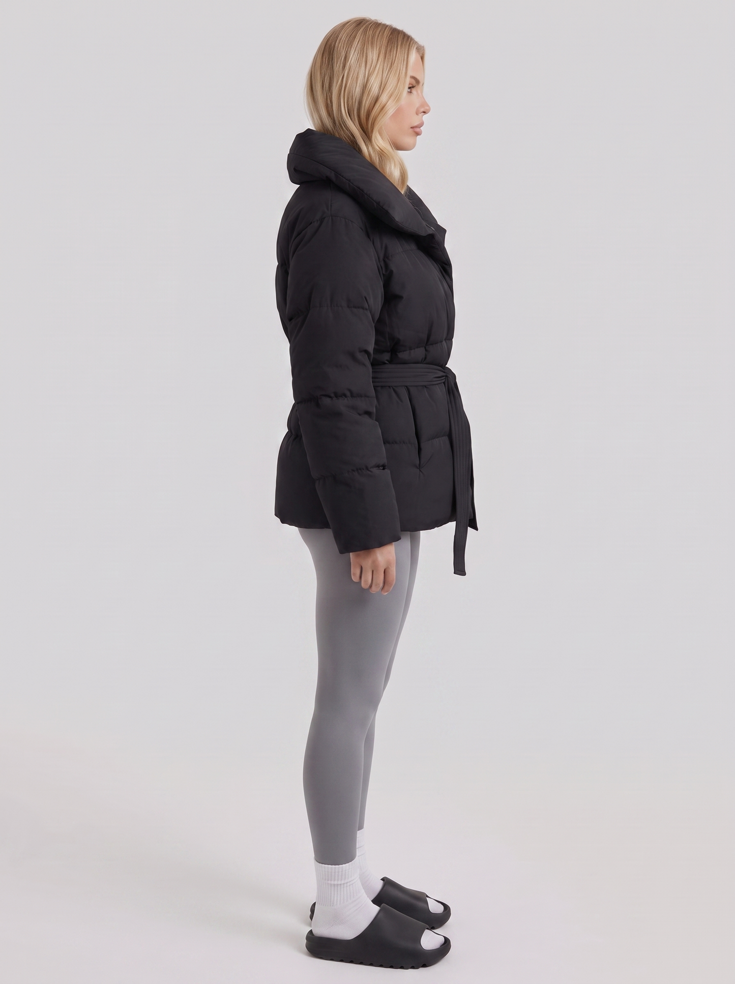 Women's black puffer jacket with quilted panels and zip front