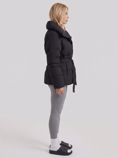 Women's black puffer jacket with quilted panels and zip front