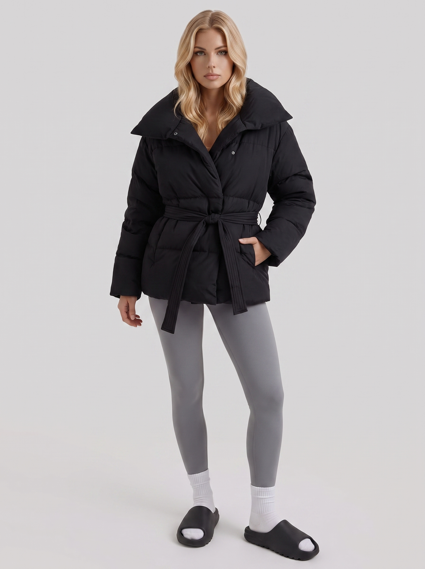 Women's black puffer jacket with quilted panels and zip front