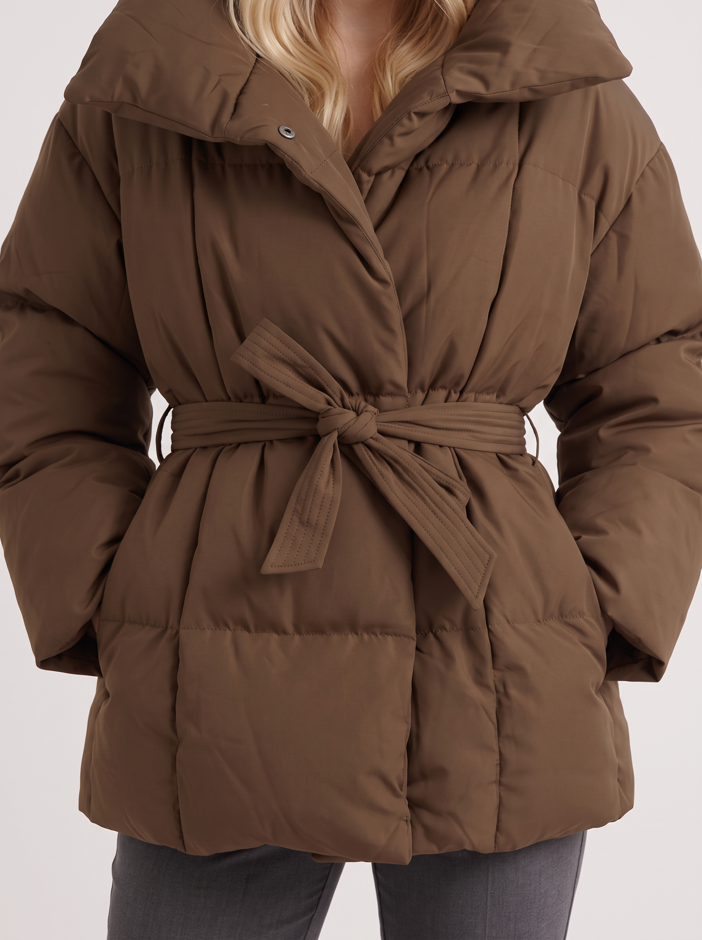 Women's brown puffer jacket with quilted panels and zip front