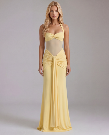 Women's yellow ruched maxi dress with halter neckline and sheer midriff, front view.